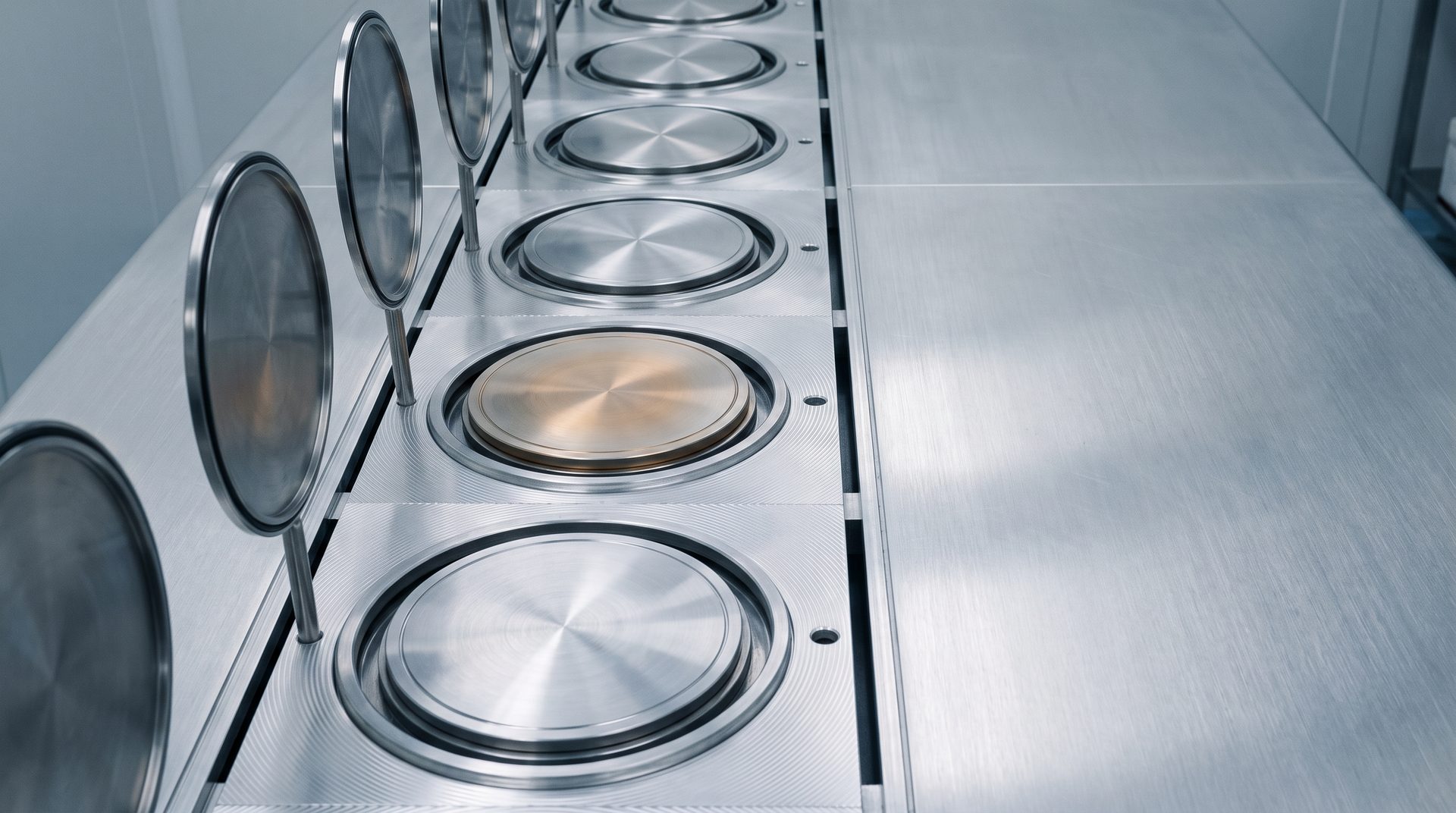 Top view of hot plate and chill plate modules in a row, metal surfaces with a sense of radiated heat, cool tones